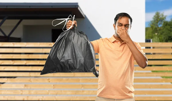 Indio hombre sosteniendo apestosa bolsa de basura — Foto de Stock