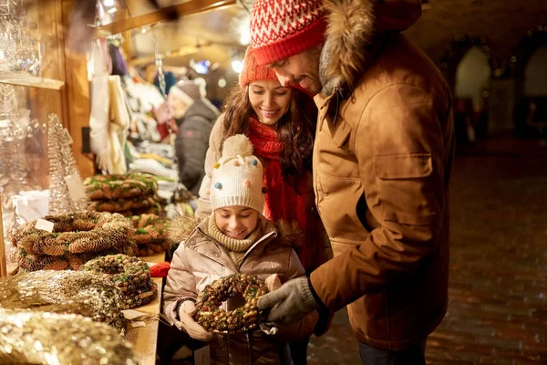 Heureux famille buing couronne au marché de Noël — Photo