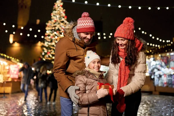 Famille heureuse avec cadeau au marché de Noël en ville — Photo