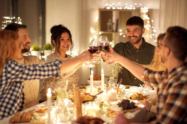 Ευτυχισμένοι φίλοι πίνοντας κόκκινο κρασί στο χριστουγεννιάτικο πάρτι — Φωτογραφία Αρχείου