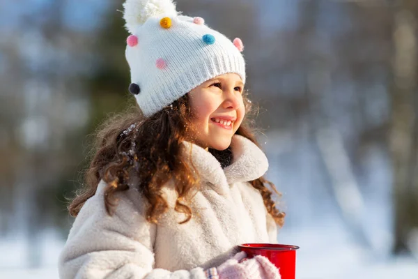 Klein meisje met kopje warme thee in de winter park — Stockfoto