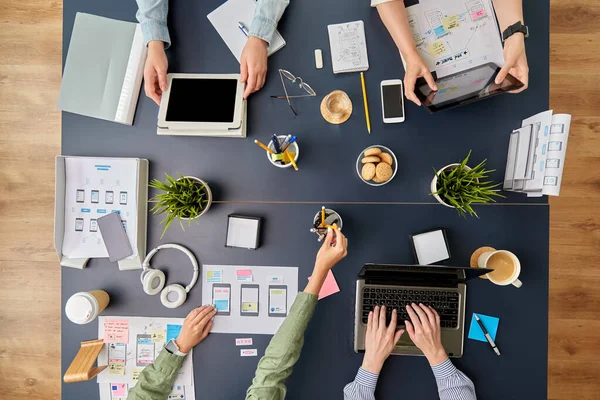 Team di lavoro con gadget che lavorano al tavolo dell'ufficio — Foto Stock