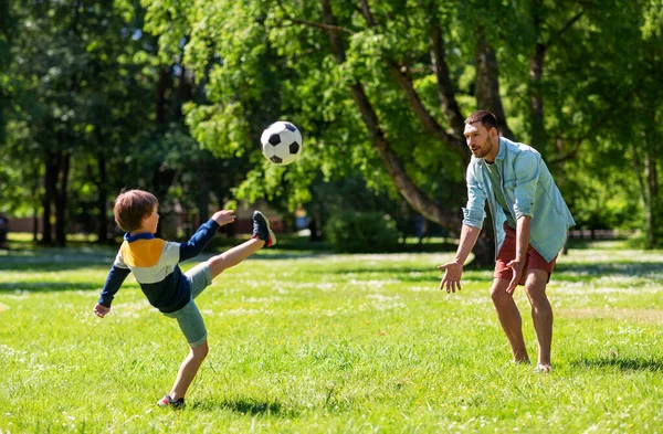 Padre con hijo pequeño jugando al fútbol en el parque — Foto de Stock