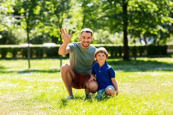 Glad leende far och liten son på sommarparken — Stockfoto