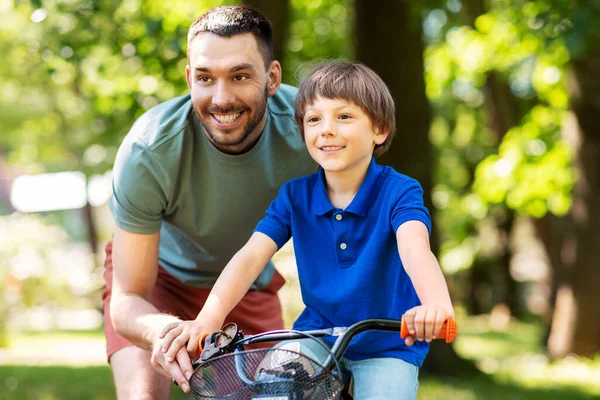 Vater bringt kleinem Sohn Fahrradfahren im Park bei — Stockfoto