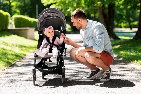 Lycklig far med barn i barnvagn på sommarparken — Stockfoto