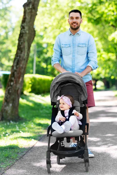 Mutlu bir baba ve çocuğu yaz parkında bebek arabasında. — Stok fotoğraf