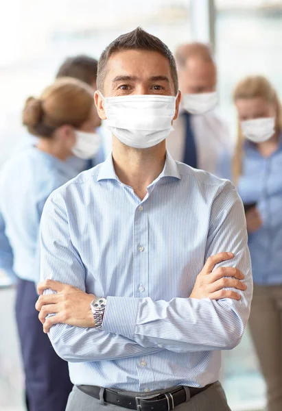 Бизнесмен в защитной маске на работе — стоковое фото