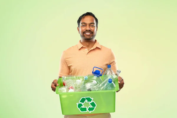 Sonriente joven indio hombre clasificación de residuos de plástico —  Fotos de Stock