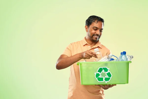 Lächelnder junger indischer Mann beim Sortieren von Plastikmüll — Stockfoto