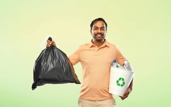 Улыбающийся индиец сортирует бумагу и пластиковые отходы — стоковое фото