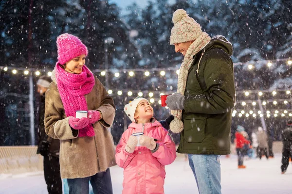 Heureux famille boire du thé chaud sur patinoire — Photo