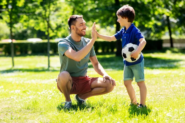 Baba parkta futbol topuyla oğluna beş veriyor. — Stok fotoğraf