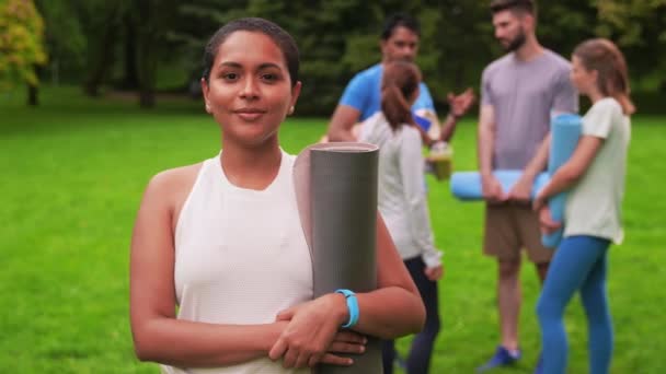 Усміхнена жінка з йоги мат над групою людей — стокове відео