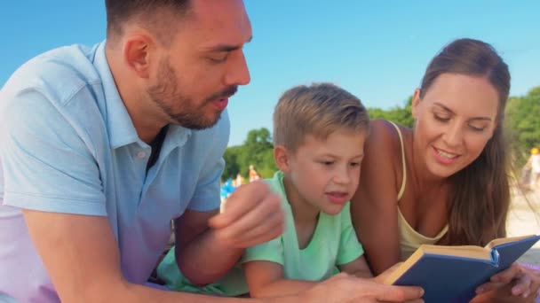 夏のビーチで家族の読書本 — ストック動画