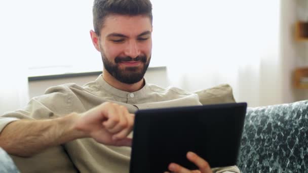 Hombre sonriente con Tablet PC en casa — Vídeos de Stock