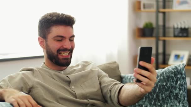 Férfi okostelefon miután video hívás otthon — Stock videók