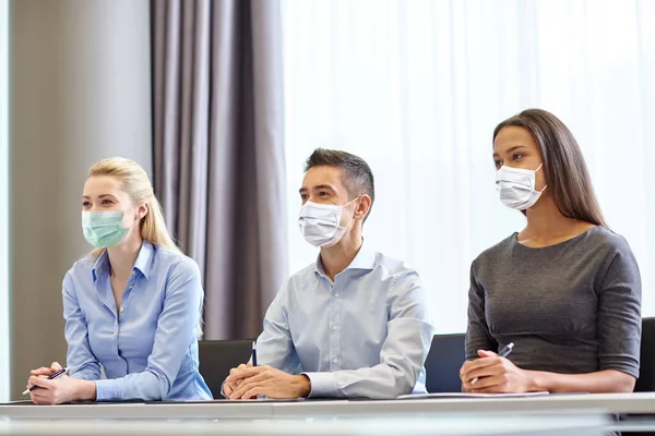 Skupina podnikatelů v maskách v kanceláři — Stock fotografie