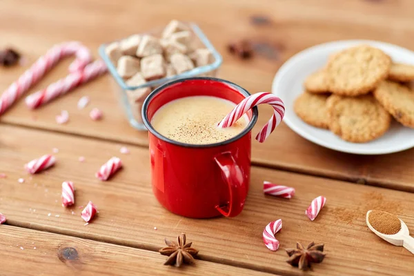 Cup of eggnog with candy cane, cookies and sugar — Stock Photo, Image