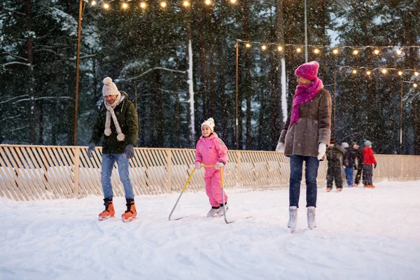 Happy family at outdoor skating rink in winter — Stock Photo, Image