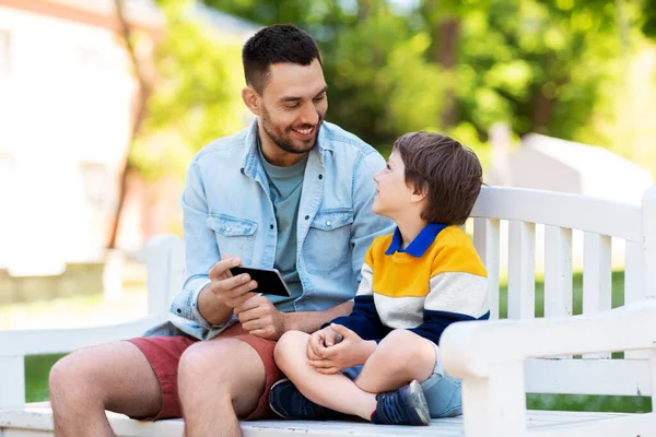 Vater und Sohn mit Smartphone im Park — Stockfoto