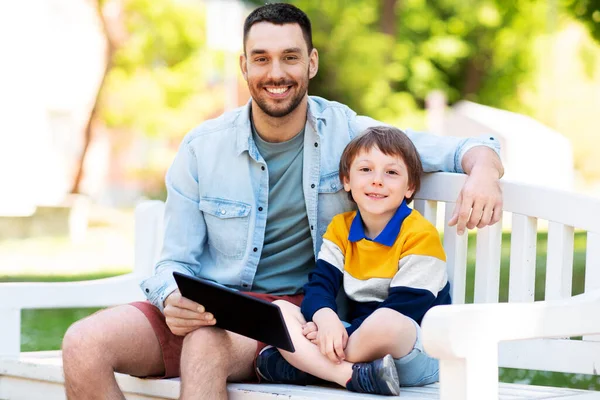 Vader en zoon met tablet pc op park — Stockfoto