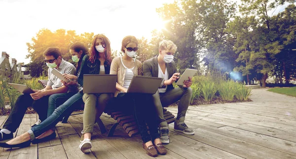 Tonårsstudenter i masker med datorer på campus — Stockfoto