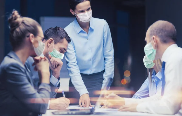 Kvinnlig chef i mask med business team på kontoret — Stockfoto