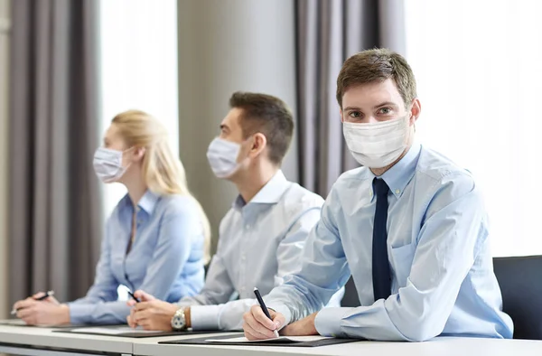 Skupina podnikatelů v maskách setkání v kanceláři — Stock fotografie