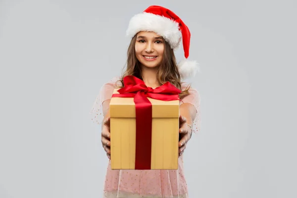 Ragazza adolescente in cappello di Babbo Natale con regalo di Natale — Foto Stock