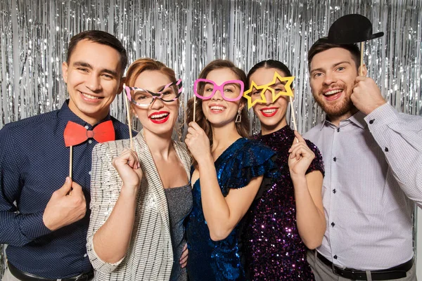 Amigos felizes posando com adereços de festa — Fotografia de Stock