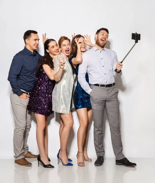 Amigos felices tomando selfie por teléfono inteligente en la fiesta —  Fotos de Stock