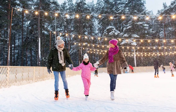 Happy family at outdoor skating rink in winter — Stock Photo, Image