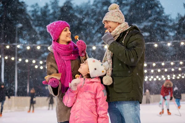 Heureux famille manger des crêpes sur patinoire — Photo