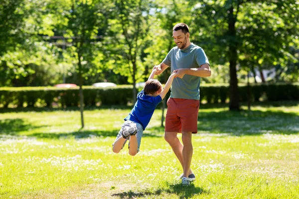 Szczęśliwy ojciec z synem bawiący się w letnim parku — Zdjęcie stockowe