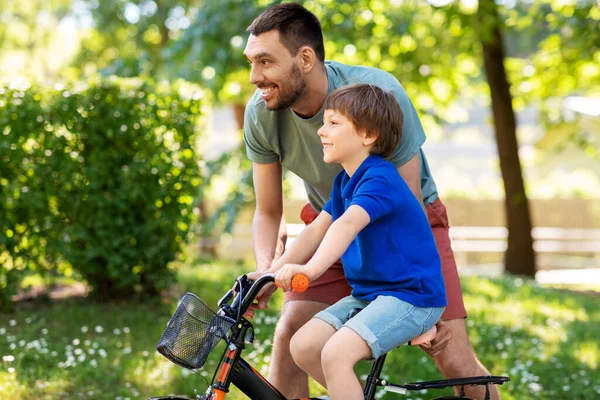 Vater bringt kleinem Sohn Fahrradfahren im Park bei — Stockfoto