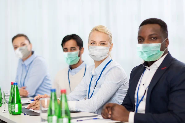 business people in masks at conference