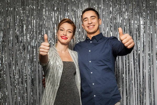 Paar in party kleding tonen duimen omhoog — Stockfoto