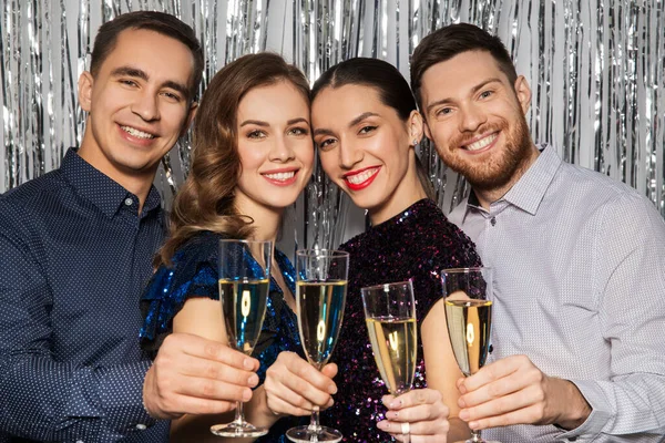 Amici felici brindare bicchieri di champagne alla festa — Foto Stock