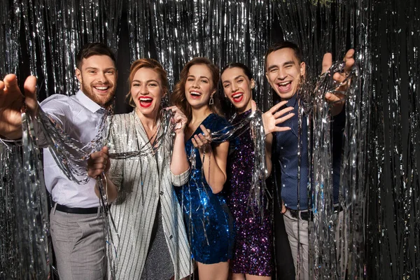 Glückliche Freunde in Partykleidung mit Lametta-Vorhang — Stockfoto