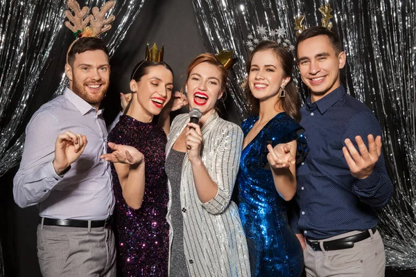 Amigos con micrófono cantando en la fiesta de Navidad — Foto de Stock