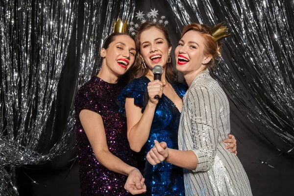 Mujeres con micrófono cantando en la fiesta de Navidad —  Fotos de Stock