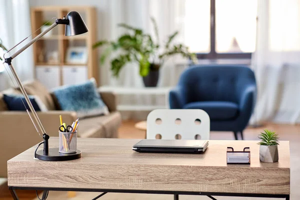 Ноутбук и лампа на столе в домашнем офисе — стоковое фото