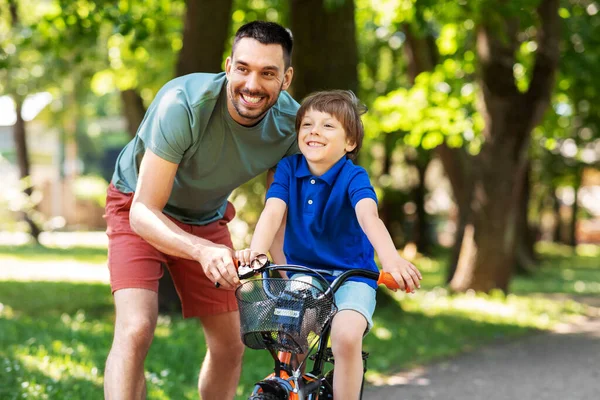 Vater bringt kleinem Sohn Fahrradfahren im Park bei — Stockfoto