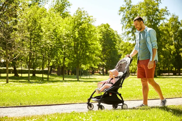 Pai feliz com criança no carrinho de bebê no parque de verão — Fotografia de Stock