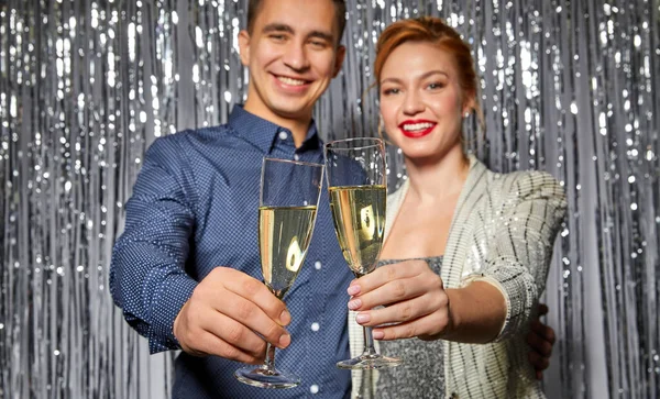 Para z kieliszkami do szampana na przyjęciu świątecznym — Zdjęcie stockowe
