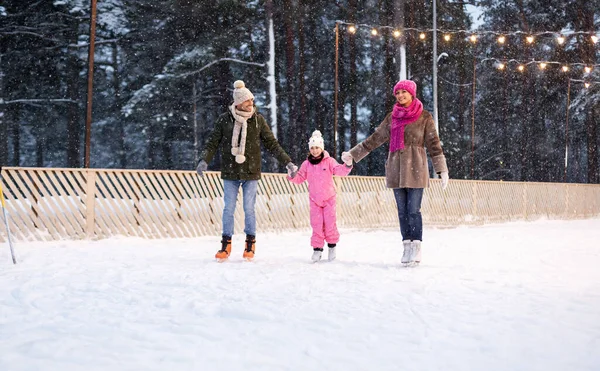 Família feliz no ringue de patinação ao ar livre no inverno — Fotografia de Stock