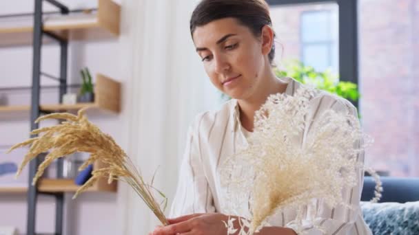 Femme arrangeant des fleurs séchées dans un vase à la maison — Video