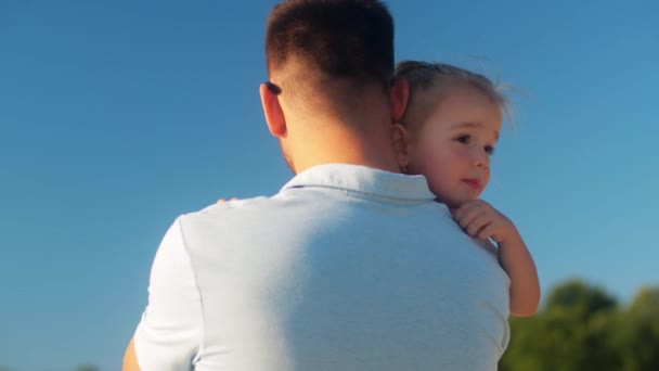 Feliz padre sosteniendo a su pequeña hija al aire libre — Vídeos de Stock