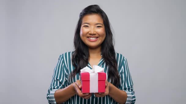 Smiling young asian woman holding gift box — Stock Video